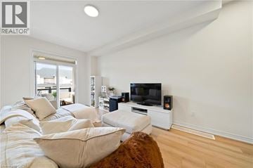 Hamilton townhouse for rent - A living room with a large couch and a television.