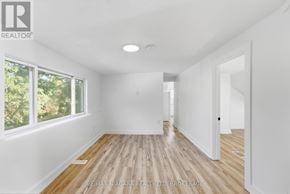 St. Catharines (Haig) apartment for rent - A spacious room with wooden flooring and white walls.
