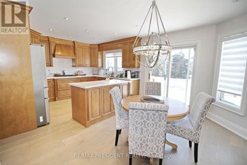 Brampton (Sandringham-Wellington) apartment for rent - A well-lit kitchen with wooden cabinets and a dining table set for two.