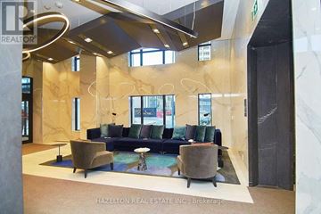Toronto (Islington-City Centre West) condo for rent - A modern living room with a blue couch and a glass wall.