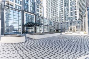Toronto (Islington-City Centre West) condo for rent - A modern building with a glass facade and a circular courtyard with a patterned floor.