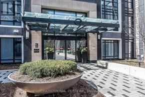 Toronto (Islington-City Centre West) condo for rent - A modern building entrance with a glass canopy and a planter in front.