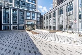 Toronto (Islington-City Centre West) condo for rent - A modern building with a glass facade and a paved courtyard in front.
