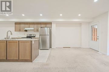 Cambridge townhouse for rent - A kitchen with wooden cabinets and a stainless steel refrigerator.