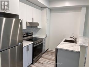 Mississauga (Churchill Meadows) townhouse for rent - A kitchen with a stainless steel refrigerator and a marble countertop.