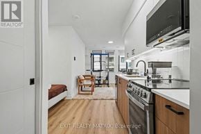 Ottawa apartment for rent - A modern kitchen with wooden floors and stainless steel appliances.