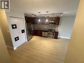Richmond apartment for rent - A kitchen with a refrigerator, oven, microwave, and cabinets.
