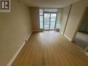Richmond apartment for rent - A spacious room with wooden flooring and a large window.