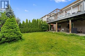Guelph (Clairfields/Hanlon Business Park) apartment for rent - A large backyard with a deck and a tree.