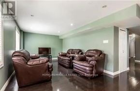 Guelph (Clairfields/Hanlon Business Park) apartment for rent - A living room with brown leather furniture and a flat screen TV.