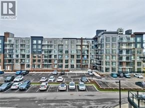 Stoney Creek condo for rent - A parking lot in front of a multi-story apartment building.