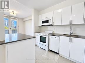 Toronto (University) condo for rent - A kitchen with white cabinets and appliances is on the market.