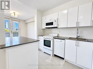 Toronto (University) condo for rent - A kitchen with white cabinets and appliances is on the market.