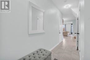 Guelph (Grange Road) townhouse for rent - A white hallway with a grey bench and a painting on the wall.
