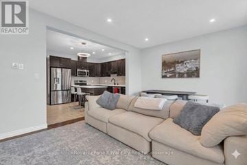 Guelph (Grange Road) townhouse for rent - A living room with a couch and a framed picture on the wall.