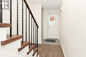 Mississauga (Creditview) apartment for rent - A hallway with a white door and a wooden staircase with black railings.