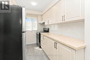 Mississauga (Creditview) apartment for rent - A kitchen with a black refrigerator and white cabinets.