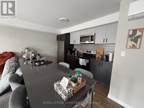 Ottawa multi-family for rent - A kitchen with a black countertop and a grey couch.