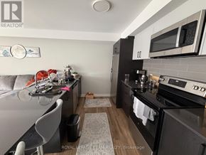 Ottawa multi-family for rent - A kitchen with a black counter top and a white fridge.