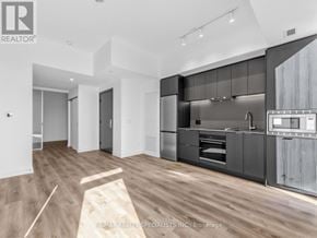 Hamilton (Beasley) condo for rent - A modern kitchen with dark wood cabinets and a white countertop.