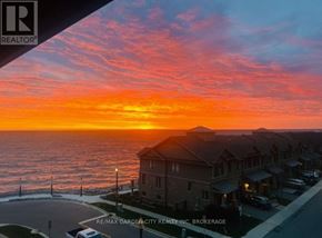 Grimsby (Grimsby Beach) condo for rent - A sunset view from a residential area with houses and a street.