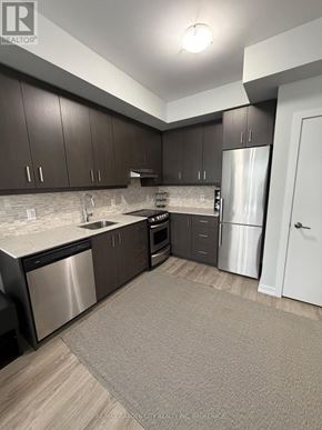 Grimsby (Grimsby Beach) condo for rent - A kitchen with dark brown cabinets and stainless steel appliances.