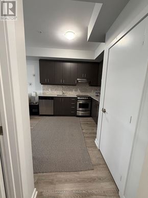 Grimsby (Grimsby Beach) condo for rent - A kitchen with a white door and a beige rug.