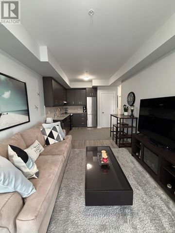Grimsby (Grimsby Beach) condo for rent - A modern living room with a beige couch and a black coffee table.