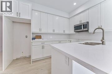 Kitchener apartment for rent - A kitchen with white cabinets and a white countertop.