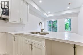 Kitchener apartment for rent - A kitchen with white cabinets and a sink.
