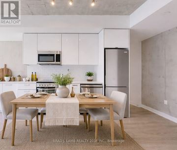 Toronto (Moss Park) condo for rent - A modern kitchen with a dining table set for two.