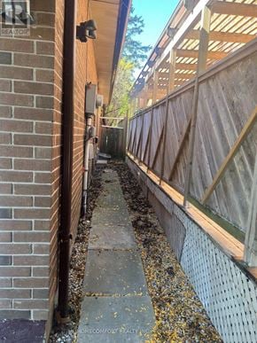 Markham (Aileen-Willowbrook) apartment for rent - A narrow walkway between two fences with a sign that says Home Comfort Realty.