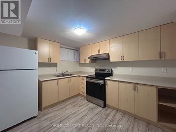 Markham (Aileen-Willowbrook) apartment for rent - A kitchen with wooden cabinets and a white fridge.