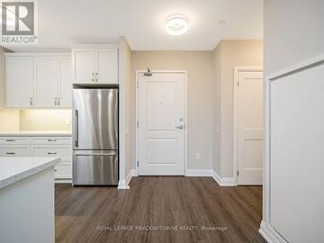 Milton (Wi Willmott) condo for rent - A kitchen with white cabinets and a stainless steel refrigerator.