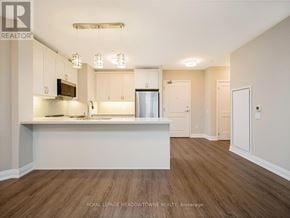 Milton (Wi Willmott) condo for rent - A kitchen with white cabinets and a wooden floor.
