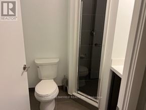 Toronto (Yorkdale-Glen Park) condo for rent - A white toilet in a small bathroom with a glass shower door.
