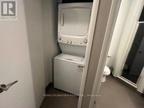 Toronto (Yorkdale-Glen Park) condo for rent - A white toilet with a bidet attachment is in a small bathroom.