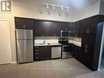 Toronto (Yorkdale-Glen Park) condo for rent - A kitchen with black cabinets and stainless steel appliances.