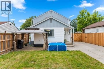Windsor apartment for rent - A house with a blue tarp covering a pool in the backyard.
