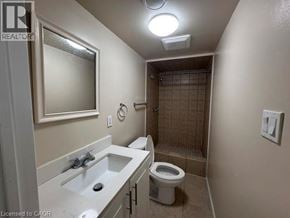 Hamilton apartment for rent - A bathroom with a toilet, sink, and shower.