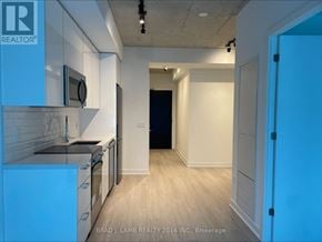 Toronto (Moss Park) condo for rent - A kitchen with white cabinets and a blue fridge.