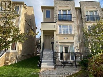 Mississauga (Churchill Meadows) townhouse for rent - A building with a black gate and a sign that says "RE/MAX Realty Shoreacres Inc Brookhage".