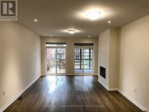 Kawartha Lakes (Bobcaygeon) townhouse for rent - A spacious room with wooden floors and a fireplace.