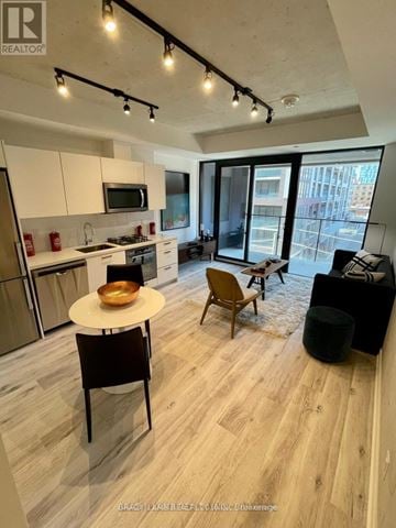 Toronto (Moss Park) condo for rent - A modern kitchen with a dining table and chairs.