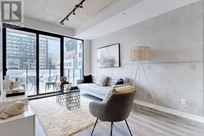 Toronto (Moss Park) condo for rent - A living room with a grey chair and a white couch.