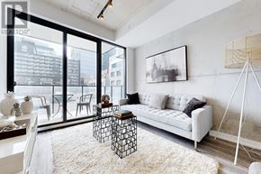 Toronto (Moss Park) condo for rent - A living room with a white couch and a large window.