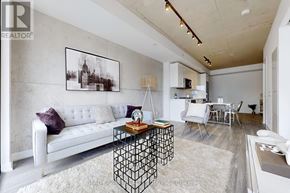 Toronto (Moss Park) condo for rent - A modern living room with a white sofa and a black and white photo on the wall.