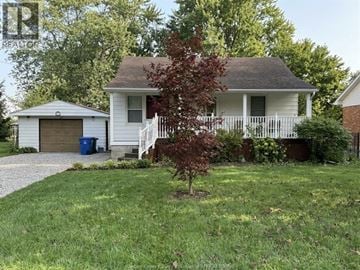 Lakeshore apartment for rent - A white house with a brown roof and a tree in front.