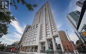 Toronto (Annex) condo for rent - A tall white building with the words "IMF REALTY Brokerage" on the front.