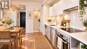Toronto (Waterfront Communities) condo for rent - A modern kitchen with stainless steel appliances and wooden chairs.
